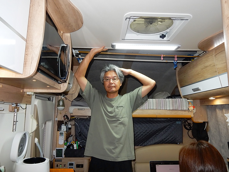 車内で直立する筆者の写真