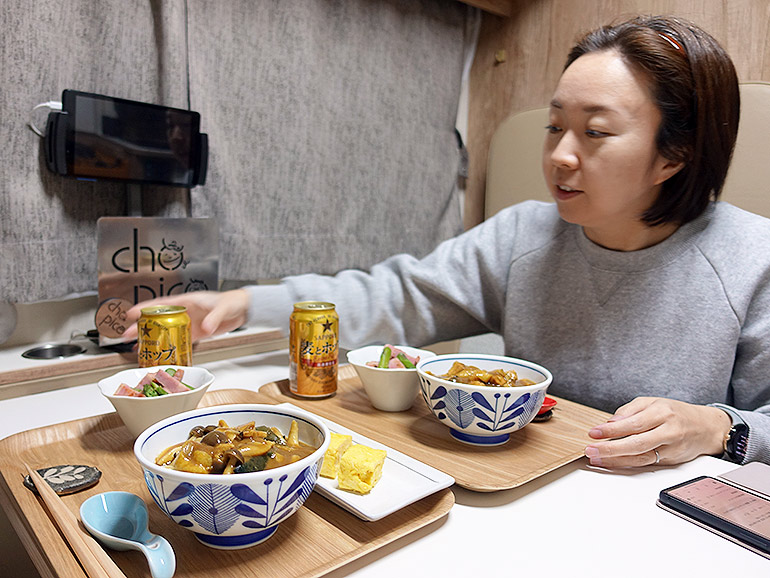 夫婦で車中飯を食べている写真